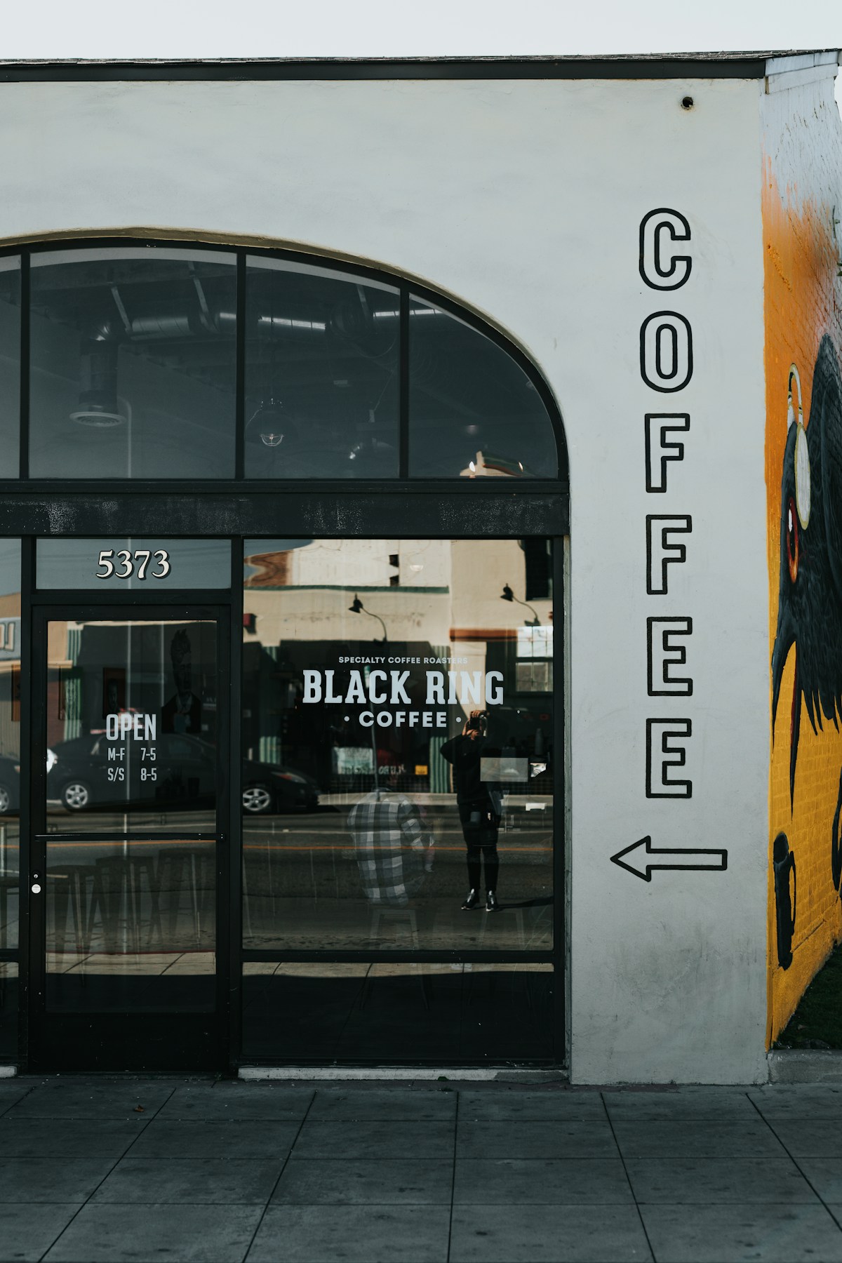 Eingang eines Cafés mit grossen Fenstern und handgemalter Beschriftung